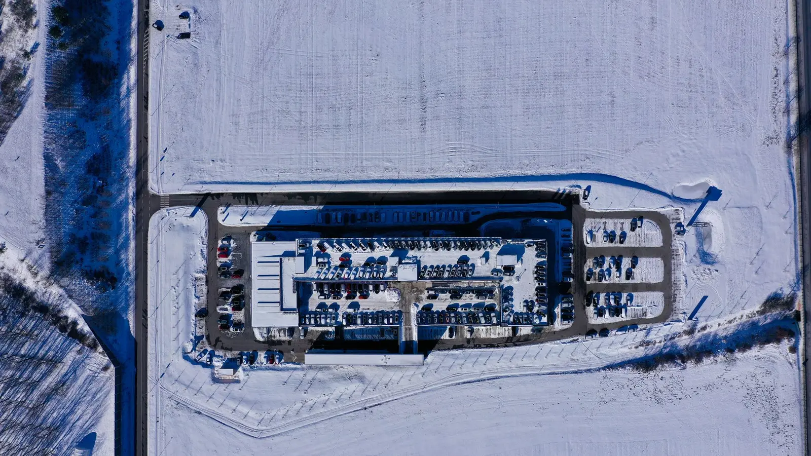 Aerial view of a commercial building with its parking lot plowed