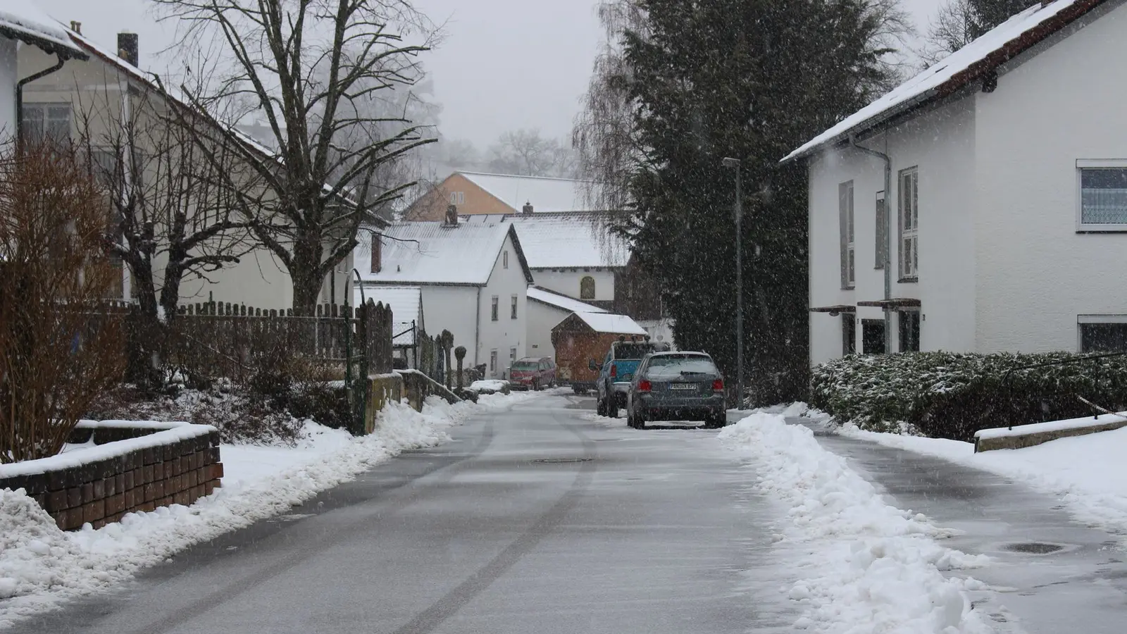 Cleared residential street with snow piled along the curbs
